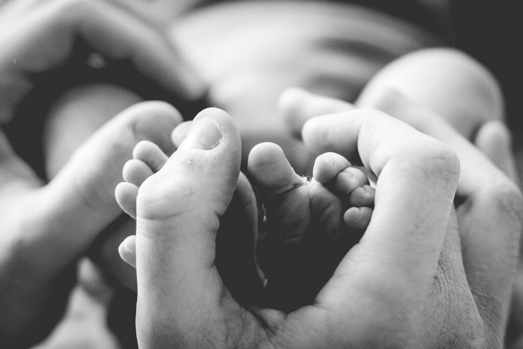 petit pied dans les mains de son papa