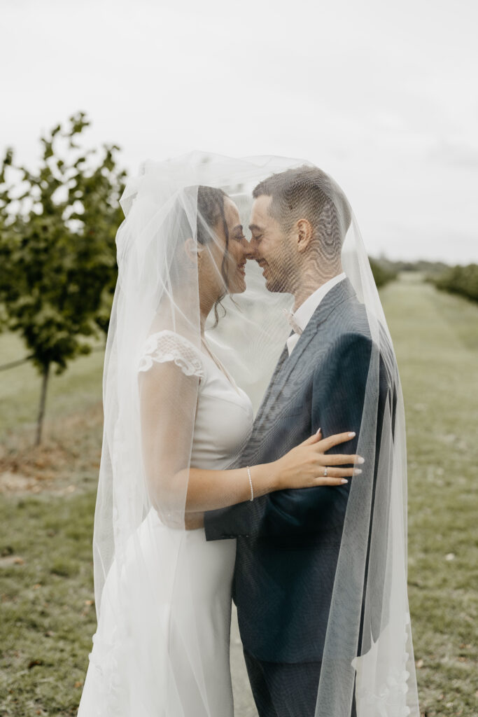 couple de marié sous le voile de la mariée